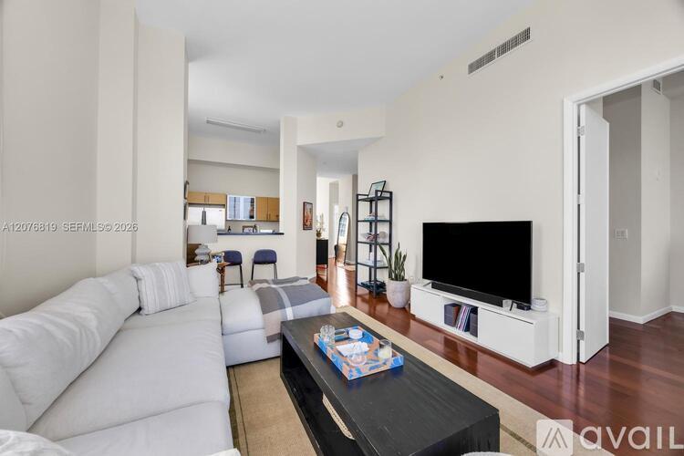 A living room with a white sofa and a black coffee table.