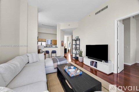 A living room with a white sofa and a black coffee table.