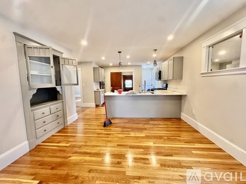 A kitchen with wooden floors and white walls.