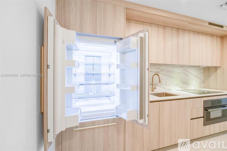 A modern kitchen with a refrigerator that is open.