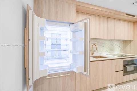 A modern kitchen with a refrigerator that is open.