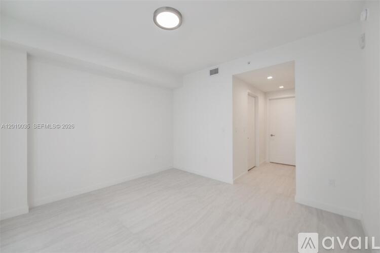 A white room with a doorway leading to another room.