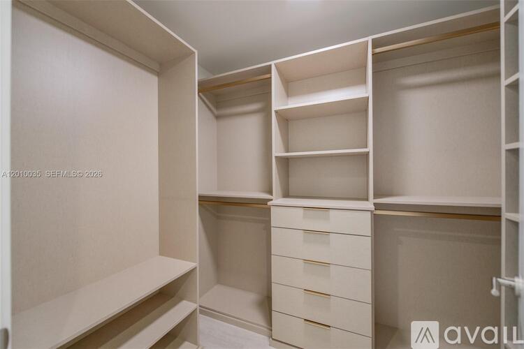 A white walk-in closet with shelves and drawers.