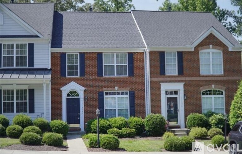 A red brick house with a black door and white trim.