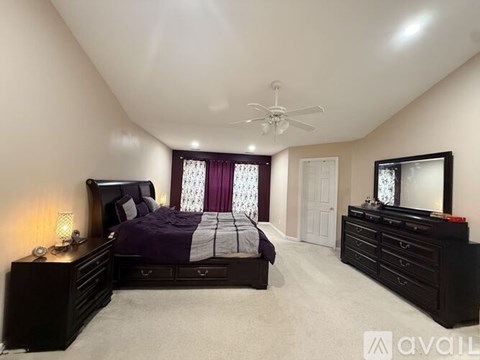 A bedroom with a bed, dresser, and mirror.
