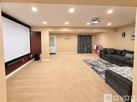 A living room with a grey couch and a carpet.