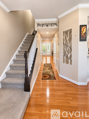 A hallway with a carpeted staircase and a rug on the floor.