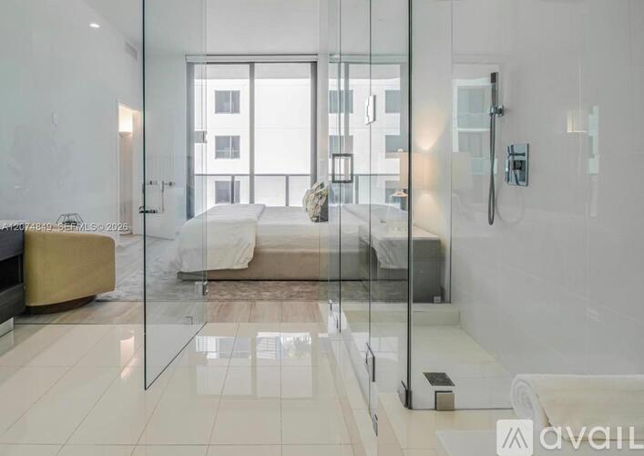 A modern bathroom with a glass shower enclosure and a large mirror.