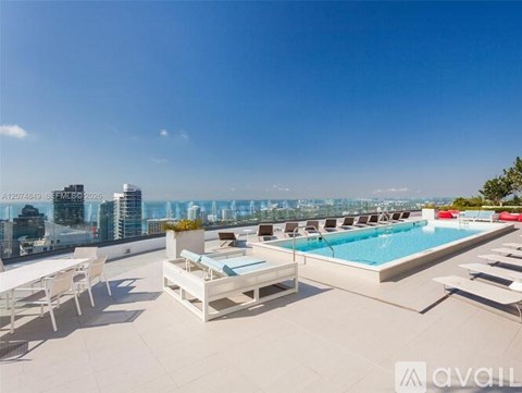 A rooftop pool area with lounge chairs and a table.
