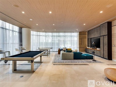 A modern living room with a pool table and a television.