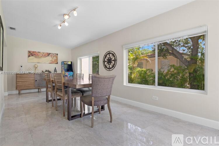 A dining room with a table and chairs.