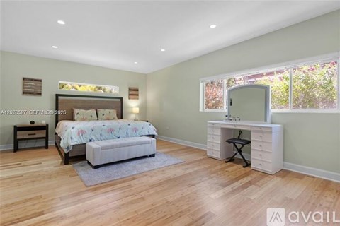 A bedroom with a bed, desk, and chair.