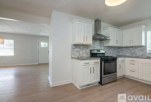 A kitchen with white cabinets and a marble countertop.