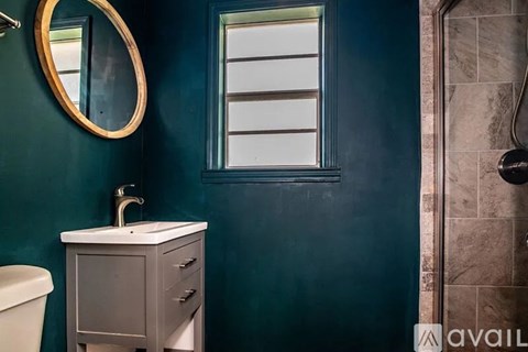 A bathroom with a green wall and a white sink.