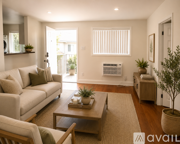 A living room with a couch, coffee table, and plants.