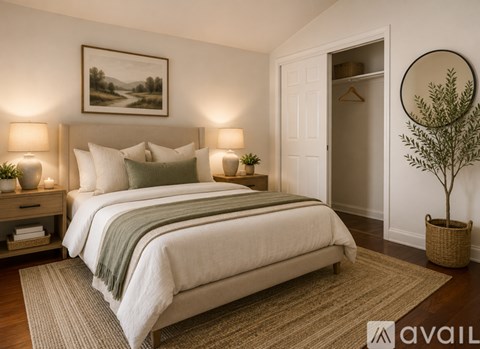 A bedroom with a large bed and a painting on the wall.