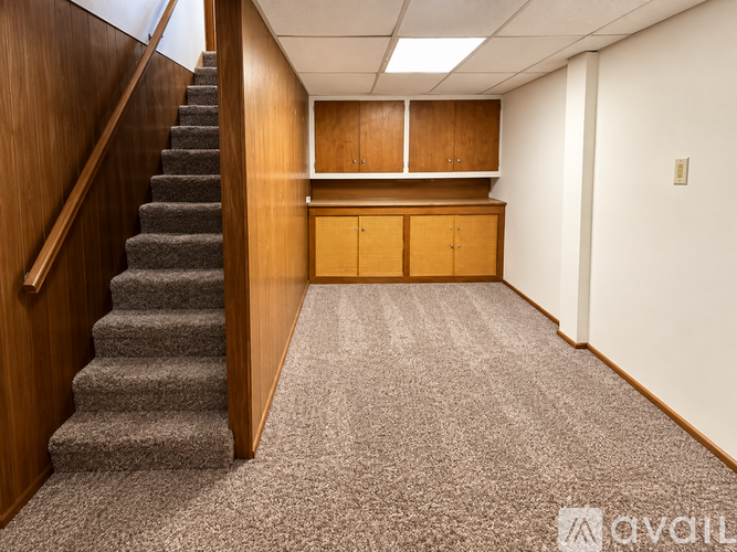 A hallway with a staircase and a cabinet.