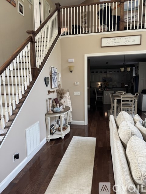 A living room with a couch and a staircase.