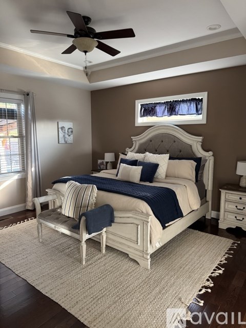 A bedroom with a large bed and a ceiling fan.