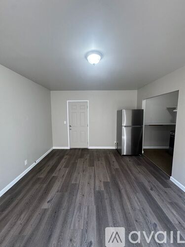 A room with wooden flooring and a white door.
