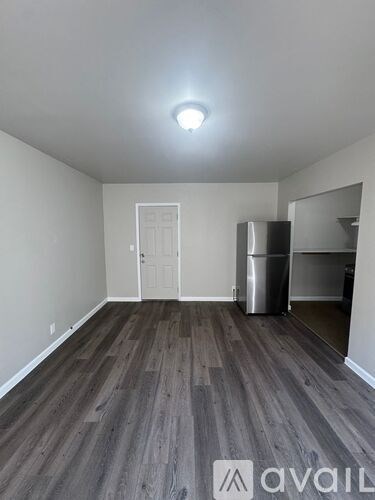 A room with wooden flooring and a white door.