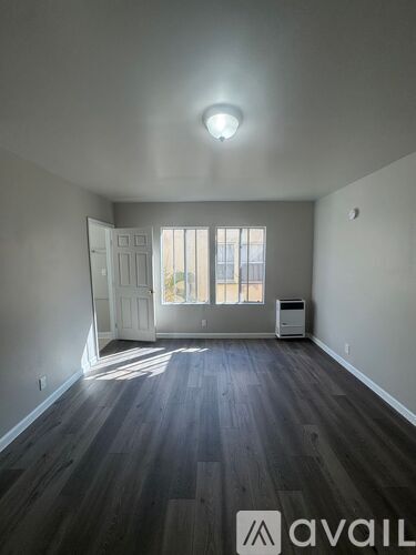 A room with a wooden floor and a white door.