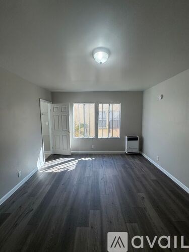 A room with a wooden floor and a white door.