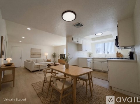 A modern kitchen with a dining table and chairs in the foreground.