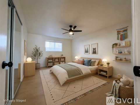 A bedroom with a bed, nightstands, and a ceiling fan.