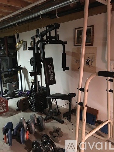 A gym with a weight machine and dumbbells.