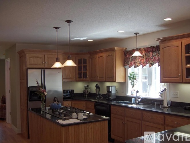 A kitchen with wooden cabinets and a black countertop.