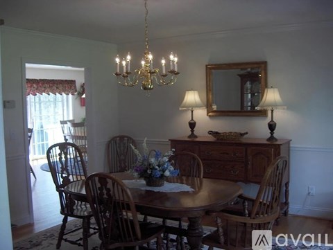 A dining room with a wooden table and chairs.