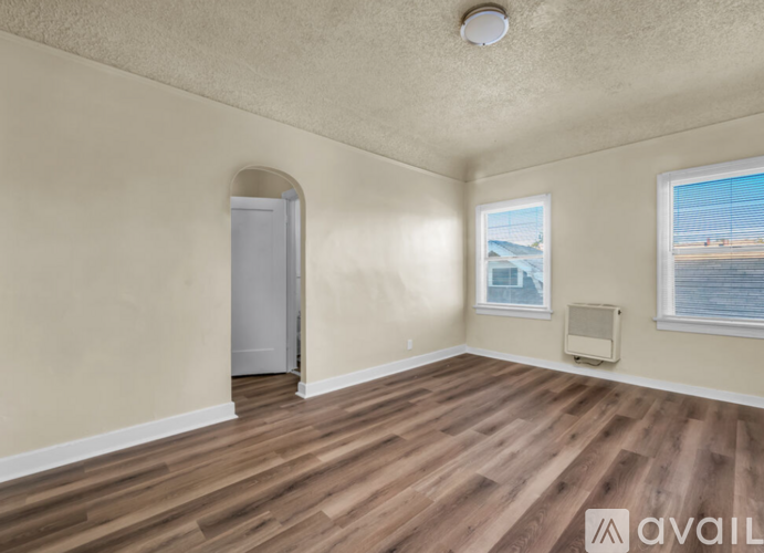 A room with wooden flooring and a window overlooking a body of water.