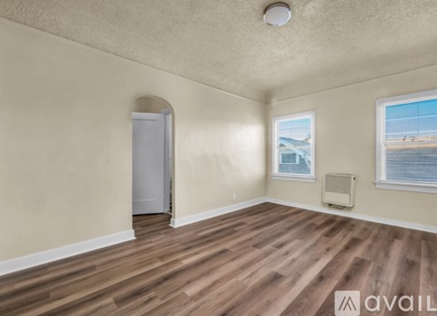 A room with wooden flooring and a window overlooking a body of water.