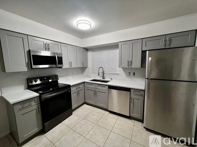 A kitchen with stainless steel appliances and white cabinets.