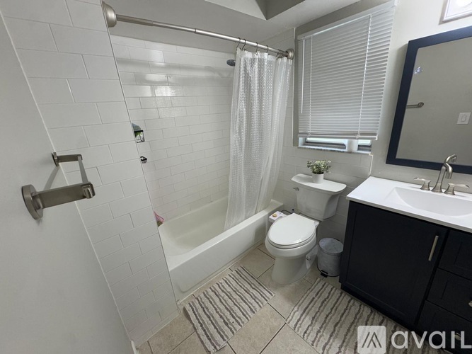 A bathroom with a toilet, sink, and shower.