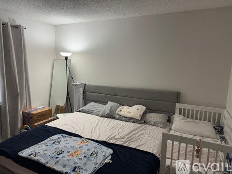 A bedroom with a bed, a lamp, and a nightstand.