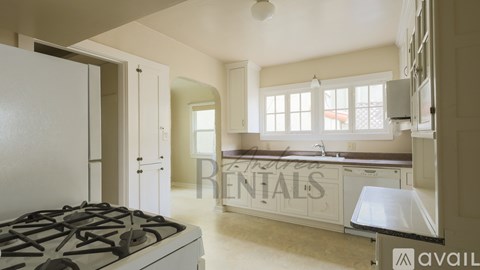 A kitchen with a stove and a countertop with a sink.