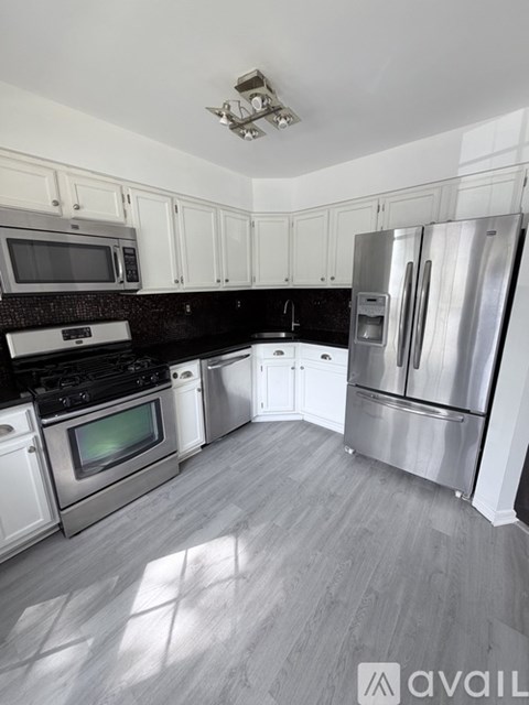 A kitchen with white cabinets and stainless steel appliances.