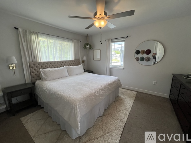 A bedroom with a large bed and a ceiling fan.