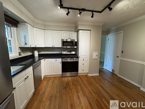 A kitchen with white cabinets and a wooden floor.