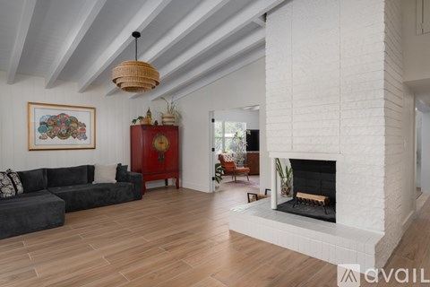 A living room with a fireplace and a painting on the wall.