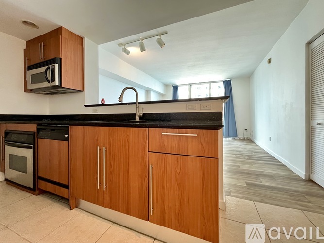 A kitchen with wooden cabinets and a black countertop.