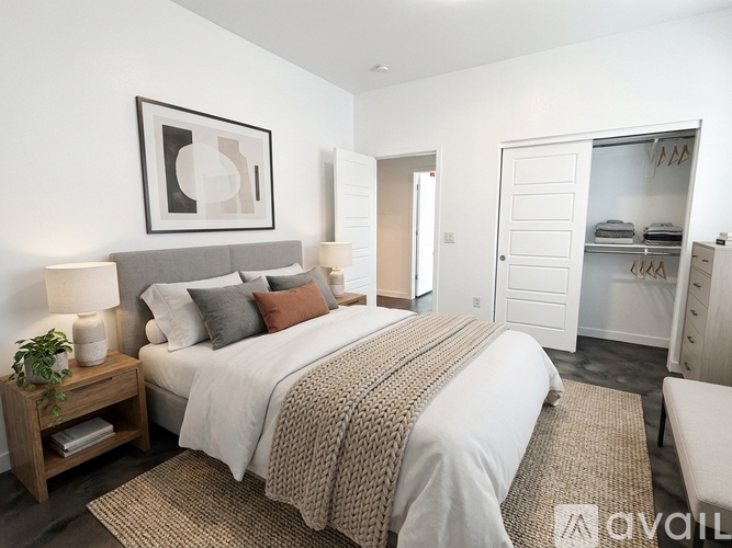 A bedroom with a large bed and a wooden nightstand.