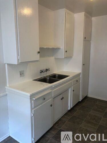 A kitchen with white cabinets and a sink.