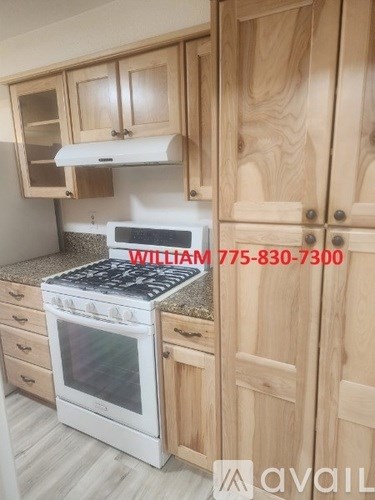 A kitchen with wooden cabinets and a stove top oven with a phone number on it.