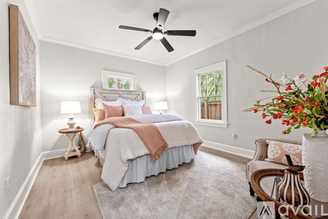 A bedroom with a bed, a chair, and a ceiling fan.