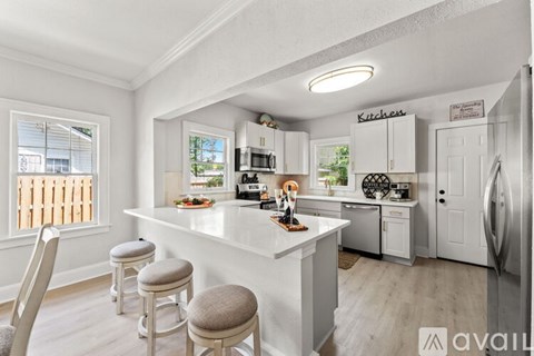 A kitchen with a white countertop and cabinets with a sign that says "Kitchen" on the wall.