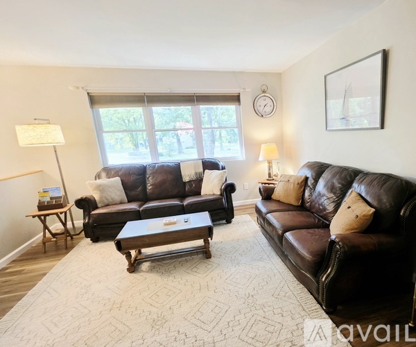 A living room with two brown leather couches and a coffee table.