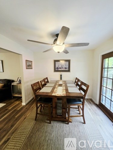 A dining room with a wooden table and chairs.